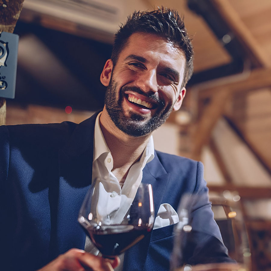 hombre sonriendo con una copa de vino